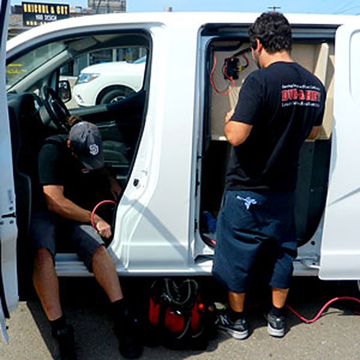 DUP-A-KEY locksmiths working on a car from the open van